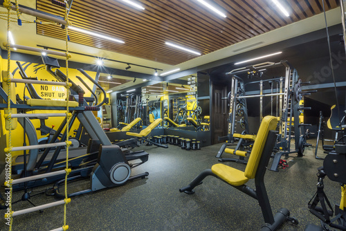A bright private gym with a variety of sports equipment. Treadmills and equipment for strength exercises.