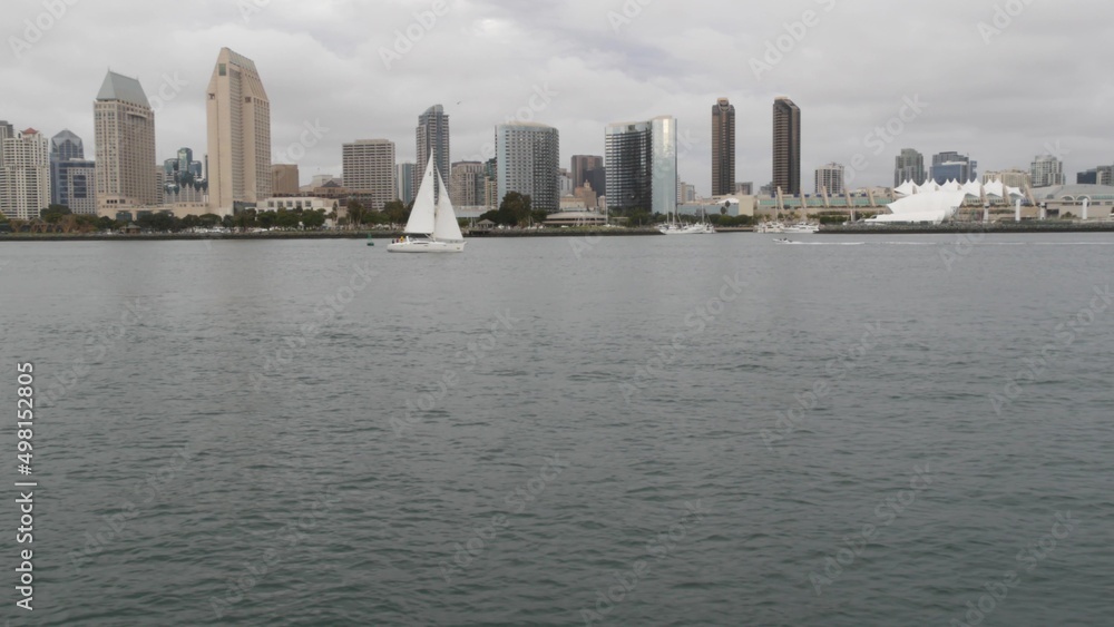 Downtown city skyline, San Diego cityscape, California USA. Waterfront highrise skyscrapers by bay. Urban architecture by harbor. Towers of financial district in Gaslamp Quarter. Overcast weather.