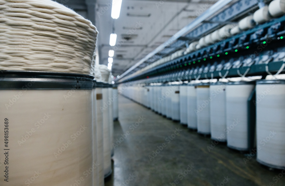 Fototapeta premium Large round containers with industrial cotton thread twisted in a spiral