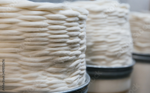 Large round containers with industrial cotton thread twisted in a spiral.