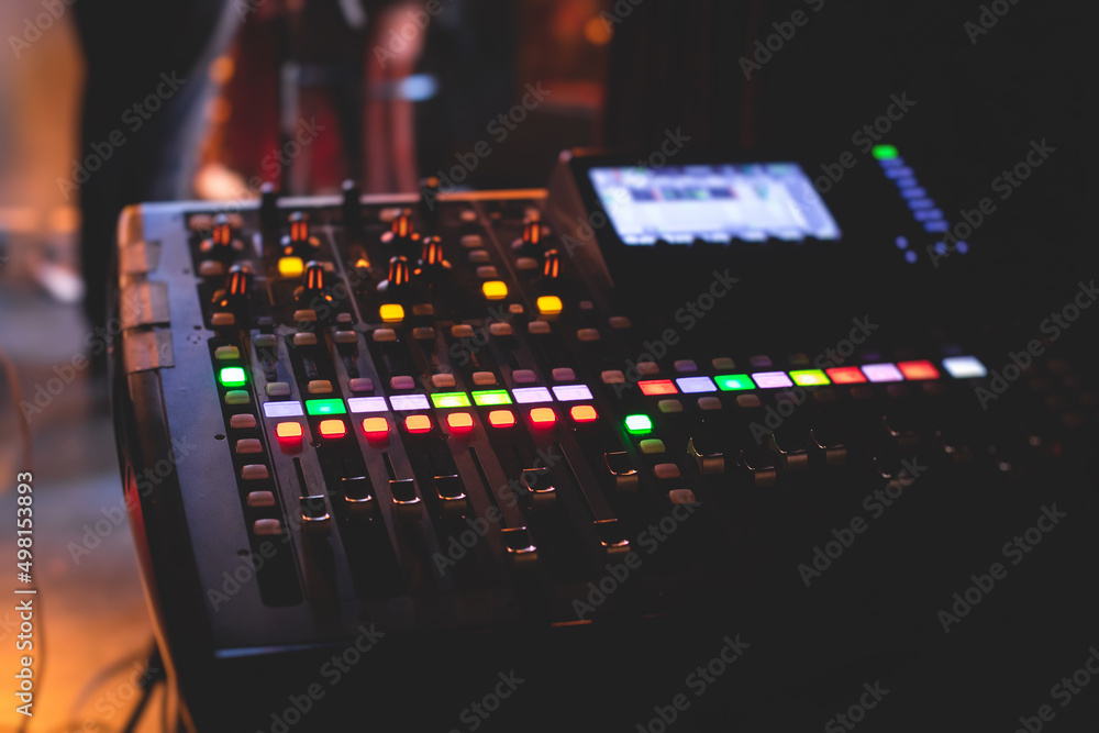 View of lighting technician operator working on mixing console workplace during live event concert on stage show broadcast, light mixer controller panel, sound technician with professional equipment View of lighting technician operator working on mixing console workplace during live event concert on stage show broadcast, light mixer controller panel, sound technician with professional equipment