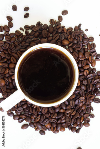Coffee beans in cup and ground coffee on white background