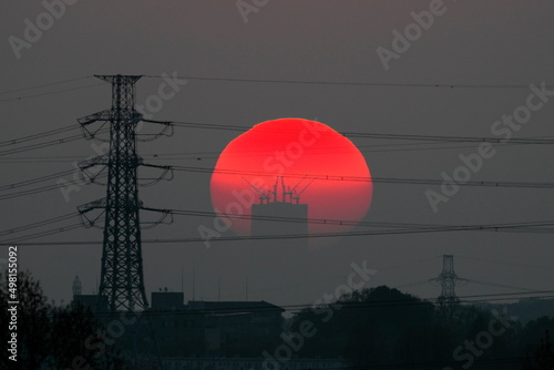 Tokyo, Japan - April 10, 2022: The morning sun rising beyond a high-rise building under construction in Tokyo, Japan
 photo