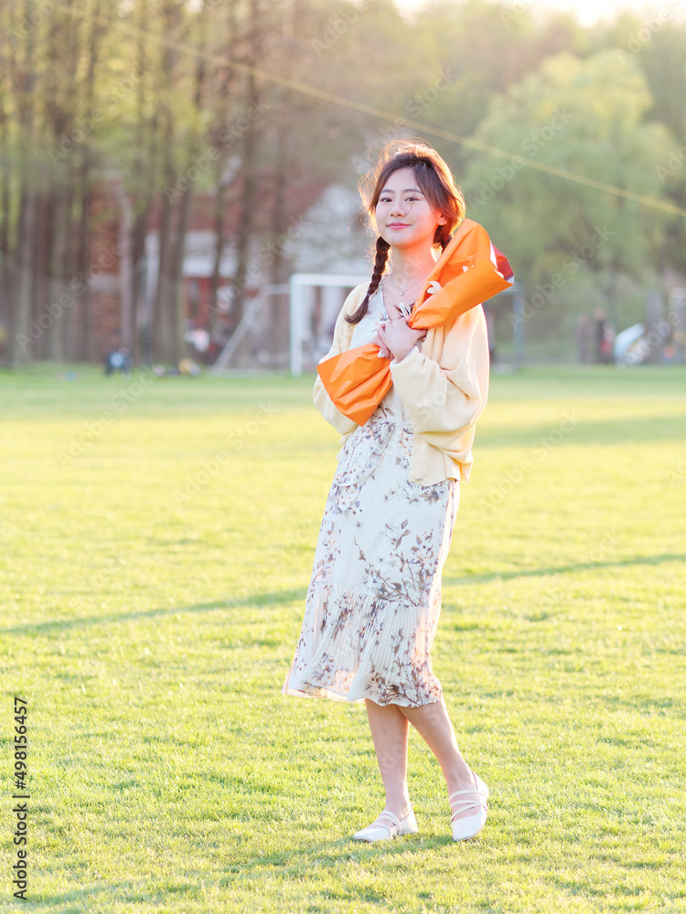 Portrait of elegant Chinese girl in dress enjoy carefree time with a bunch of flowers in her arms in forest park in sunny day. Outdoor fashion portrait of glamour young Chinese cheerful stylish woman Portrait of elegant Chinese girl in dress enjoy carefree time with a bunch of flowers in her arms in forest park in sunny day. Outdoor fashion portrait of glamour young Chinese cheerful stylish woman