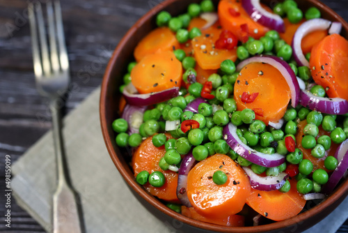 Selective focus. Macro. Healthy salad bowl with green peas, carrots and blue onions. Diet food. Fitness salad.
