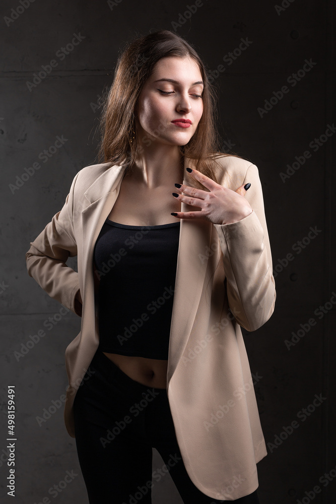Portrait of a young brunette with long hair in the studio. Dramatic photo in dark colors. Portrait of a young brunette with long hair in the studio. Dramatic photo in dark colors.