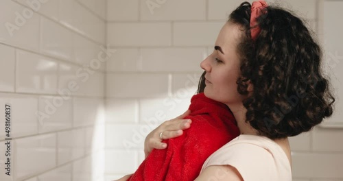 Mom wipes her daughter with a red towel and hugs her in the bathroom. Mother's hugs.