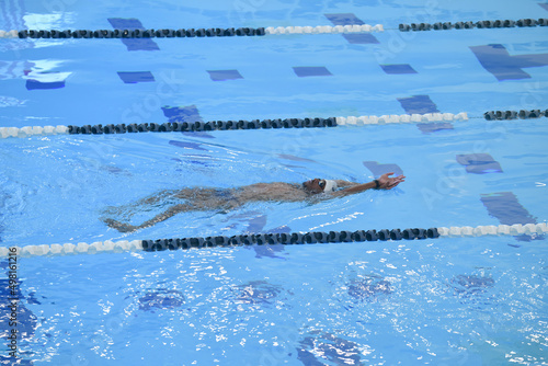 African American man swimming backstroke indoor pool