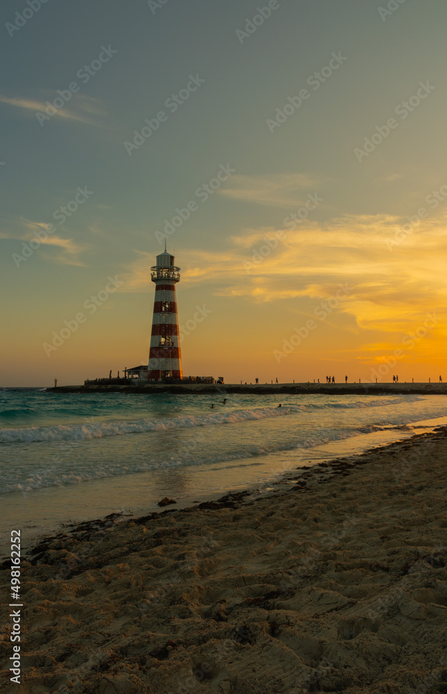 Sunset on paradise island with trees and clouds in the sky with lighthouse.