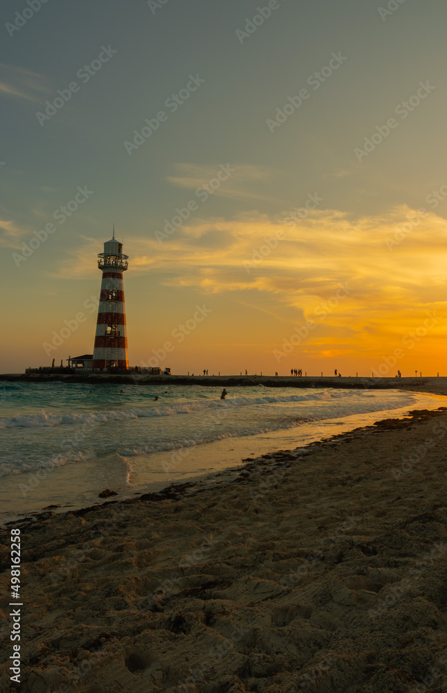 Fototapeta premium Sunset on paradise island with trees and clouds in the sky with lighthouse.
