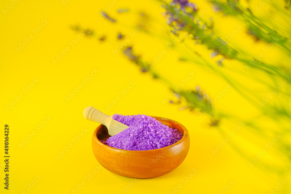 lavender salt.purple sea bath salt in a round wooden cup and blooming lavender on a bright yellow background.body cosmetic with lavender extract.Aromatherapy and spa.lilac salt with lavender extract lavender salt.purple sea bath salt in a round wooden cup and blooming lavender on a bright yellow background.body cosmetic with lavender extract.Aromatherapy and spa.lilac salt with lavender extract