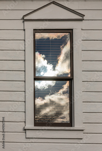 Clouds reflected in windows of a town house
