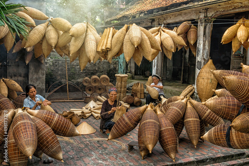 Group of Old Vietnamese female craftsman making the traditional bamboo fish trap or weave at the old traditional house in Thu sy trade village, Hung Yen,Vietnam, traditional artist concept
