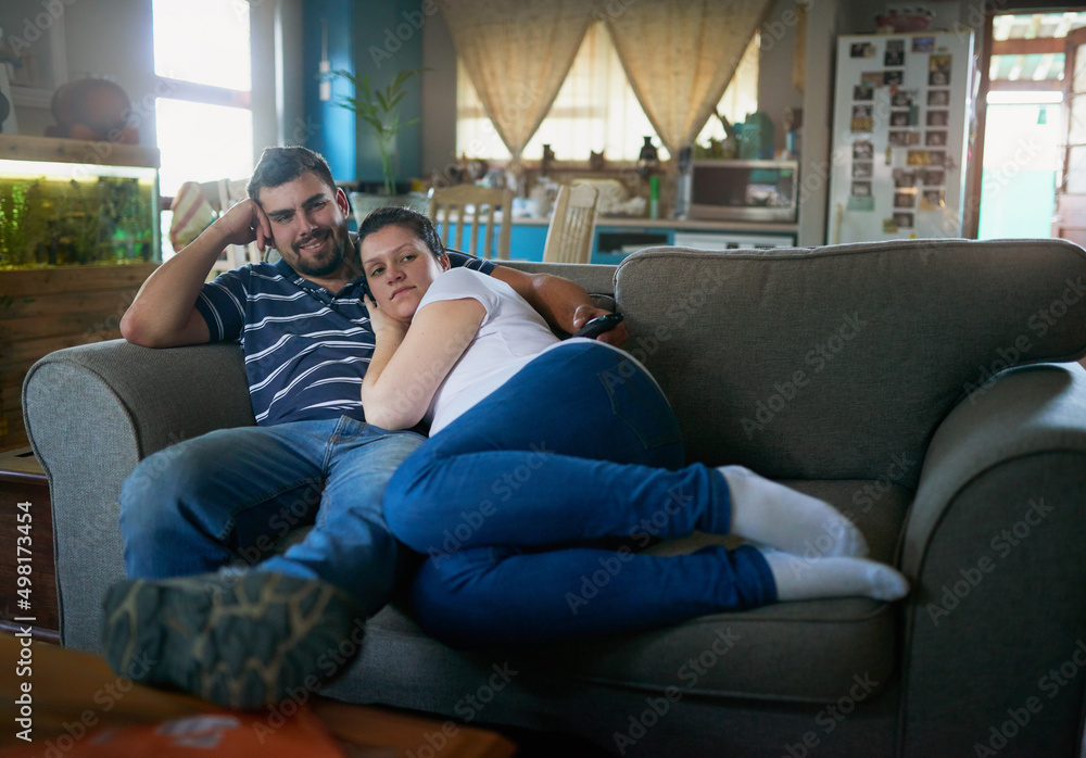 Soon well be a family. Shot of a loving pregnant couple relaxing on the couch together at home.