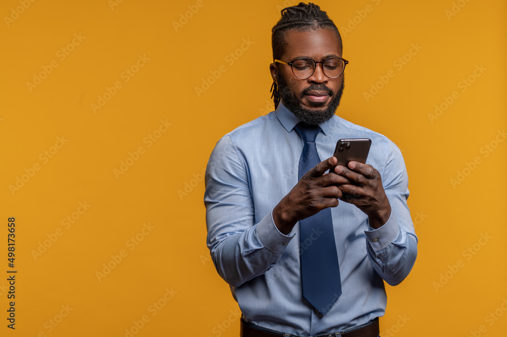 Concentrated young entrepreneur looking at his smartphone Concentrated young entrepreneur looking at his smartphone