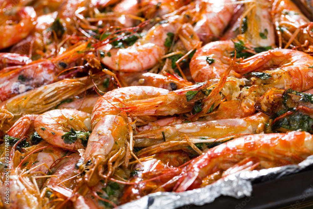 Dish of Mediterranean cuisine - baked in oven tiger shrimps with herbs