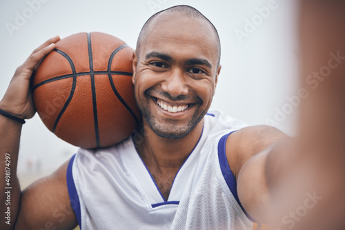 These will go in my catalogue. Shot of a young male basketball player taking a selfie while holding the ball.
