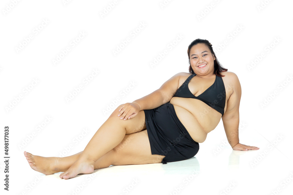 Fat woman wearing swimsuit and sitting in studio Fat woman wearing swimsuit and sitting in studio
