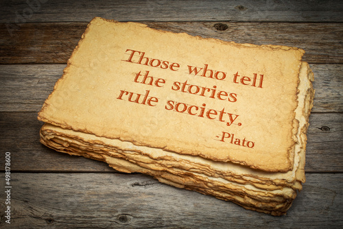 Those who tell the stories rule society, Plato, ancient Greek philosopher, quote. Inspirational handwriting on handmade paper with rough edges against rustic weathered wood, storytelling and narration photo