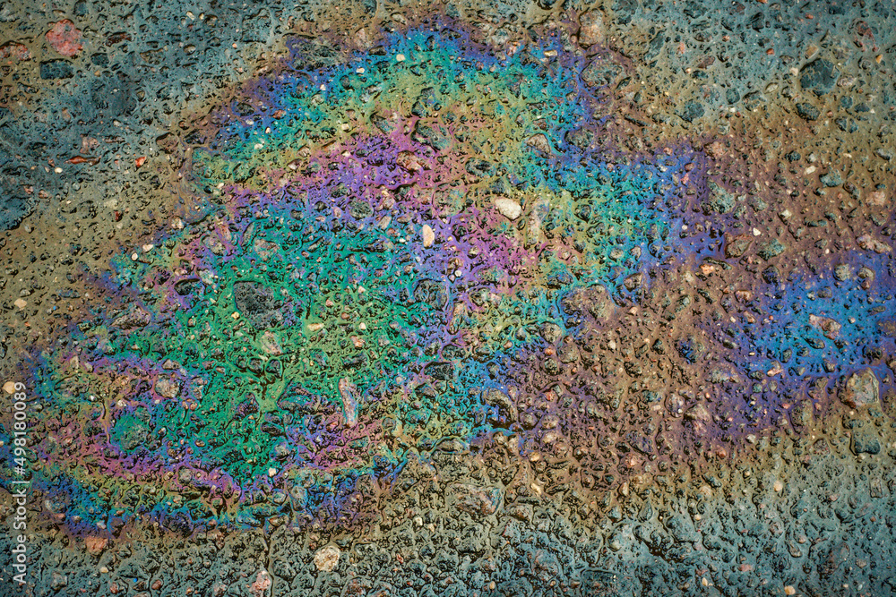 Obraz premium Oil slick on the asphalt road background