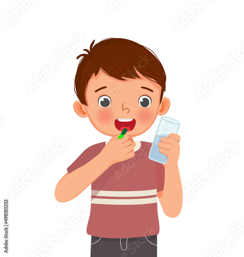 cute little boy taking a medicine capsule with a glass of water