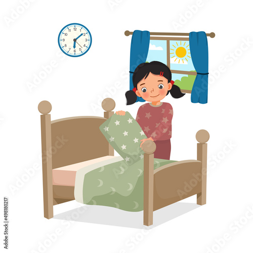 cute little girl making bed arranging pillow and bed cover neat doing her housework chores in the morning at home