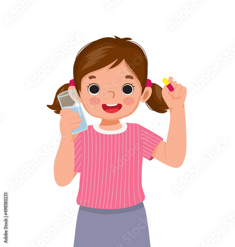 happy little girl taking a medicine capsule with a glass of water