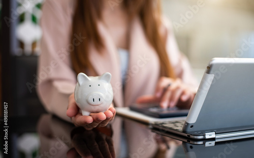 woman hand putting coin into piggy bank. Saving and financial accounts concept. .