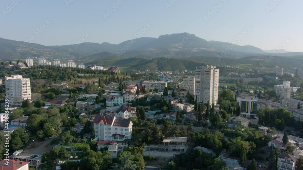 Flickering swallows over the roofs of Alushta. Amazing panorama of the Crimean resort against the background of mountains. Flickering swallows over the roofs of Alushta. Amazing panorama of the Crimean resort against the background of mountains.