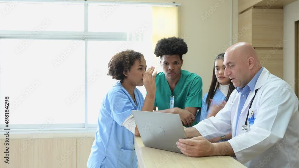 A medical professor gives advice on patient examinations to medical students practicing in an international medical hospital. A medical professor gives advice on patient examinations to medical students practicing in an international medical hospital.