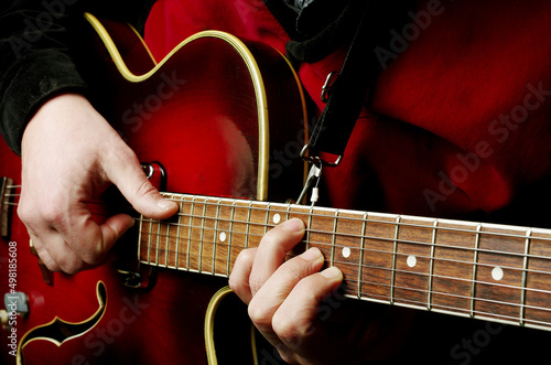 The guitarist plays the jazz electric guitar. Close-up.