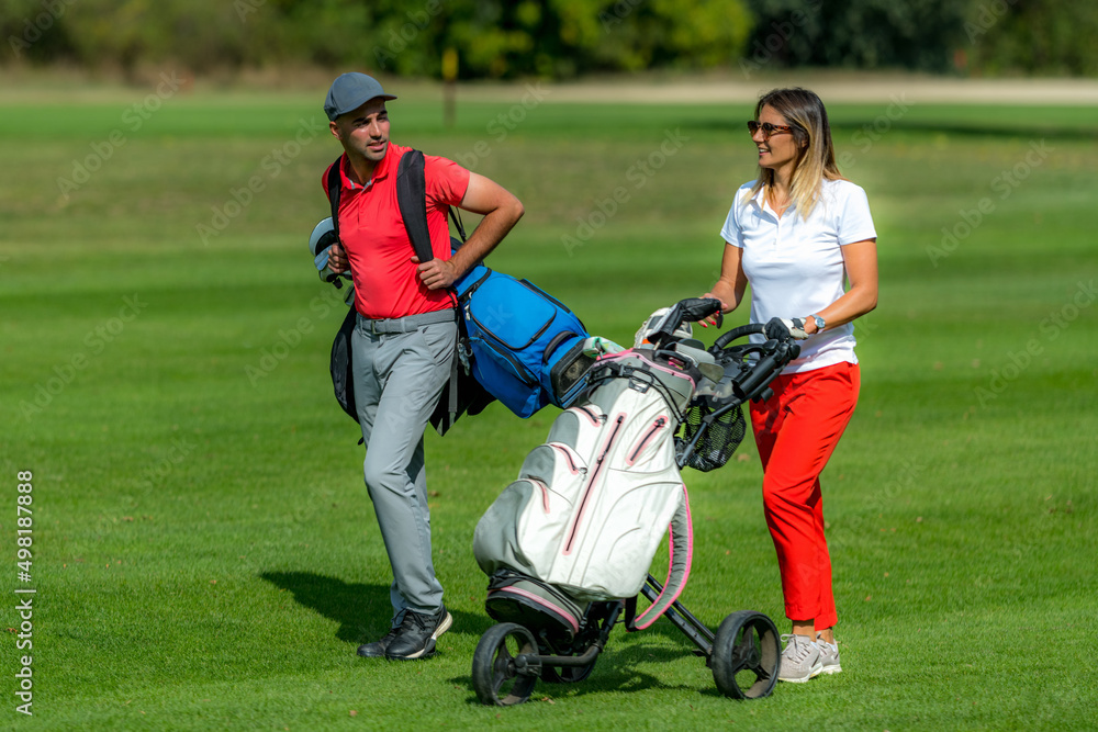 Golfing friends, enjoying a game of golf in a beautiful weather Golfing friends, enjoying a game of golf in a beautiful weather