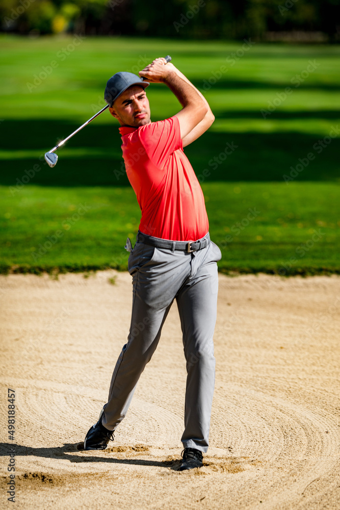 Sand wedge shot, professional golfer playing from a sand bunker
