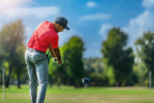 Pro golfer in a golf swing, using a driver golf club, rear view photo