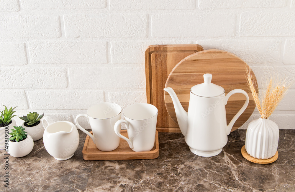 coffee set of dishes on a marble countertop against the background of a kitchen board and a white brick wall. ecologically clean kitchen.. coffee set of dishes on a marble countertop against the background of a kitchen board and a white brick wall. ecologically clean kitchen..