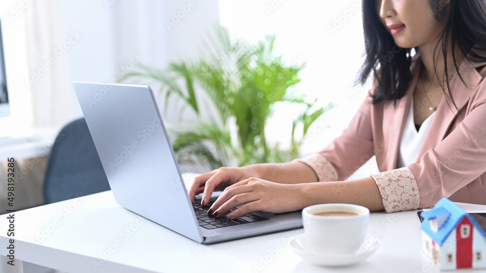 Young woman office worker sitting at her workplace and using laptop computer. Young woman office worker sitting at her workplace and using laptop computer.