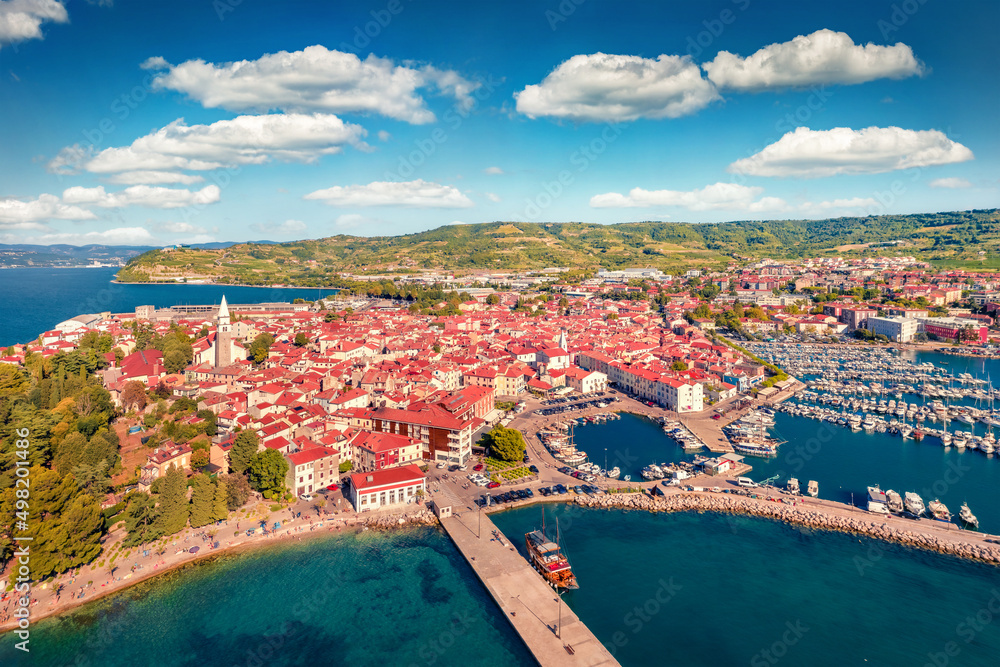 Captivating summer cityscape of Izola town, Slovenia. Superb morning seascape of Adriatic sea. View from flying drone of old sea port. Сharm of the ancient cities of Europe. 