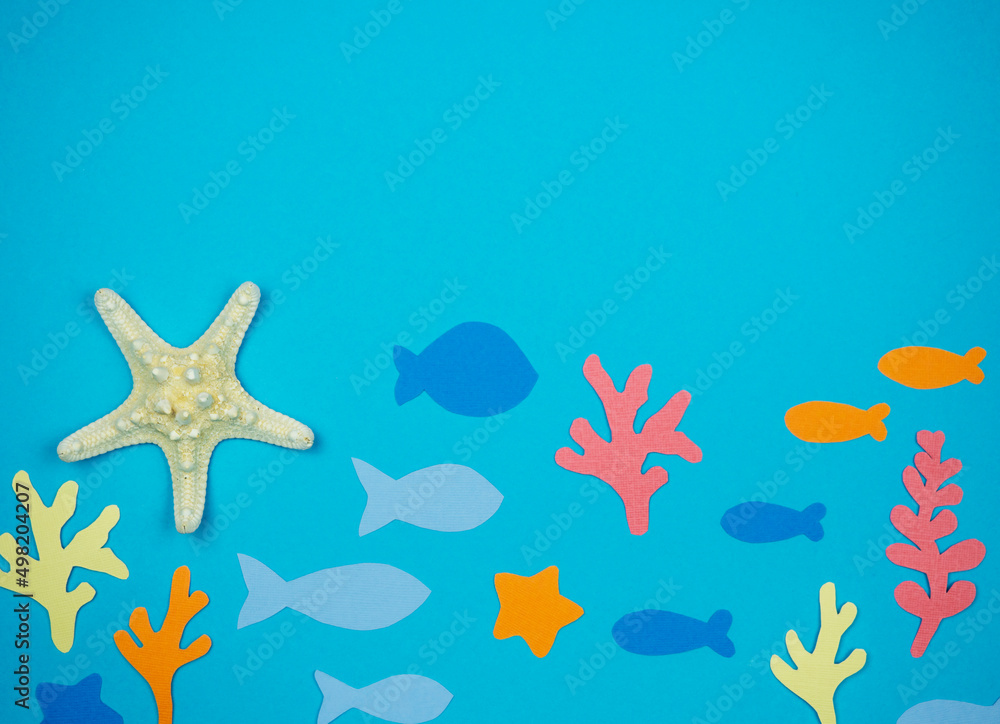 Starfish with seashells and fish made of paper on a blue background. Recreation Concept Starfish with seashells and fish made of paper on a blue background. Recreation Concept