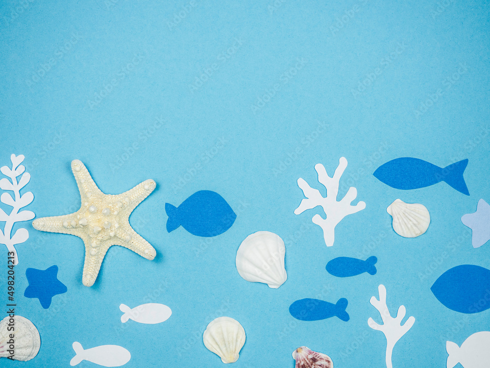 Starfish with seashells and fish made of paper on a blue background. Recreation Concept Starfish with seashells and fish made of paper on a blue background. Recreation Concept