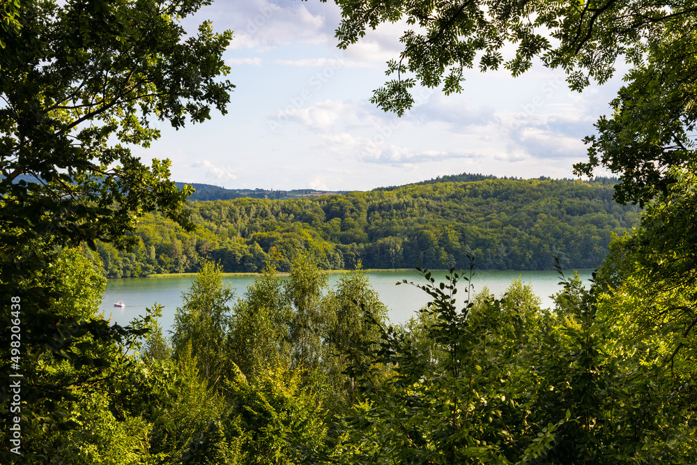 Panoramic view of Jezioro Ostrzyckie lake with shores of forest seen from Jastrzebia Gora Hawk Mountain in Ostrzyce village of Kashubia in Pomerania region of Poland - obrazy, fototapety, plakaty 