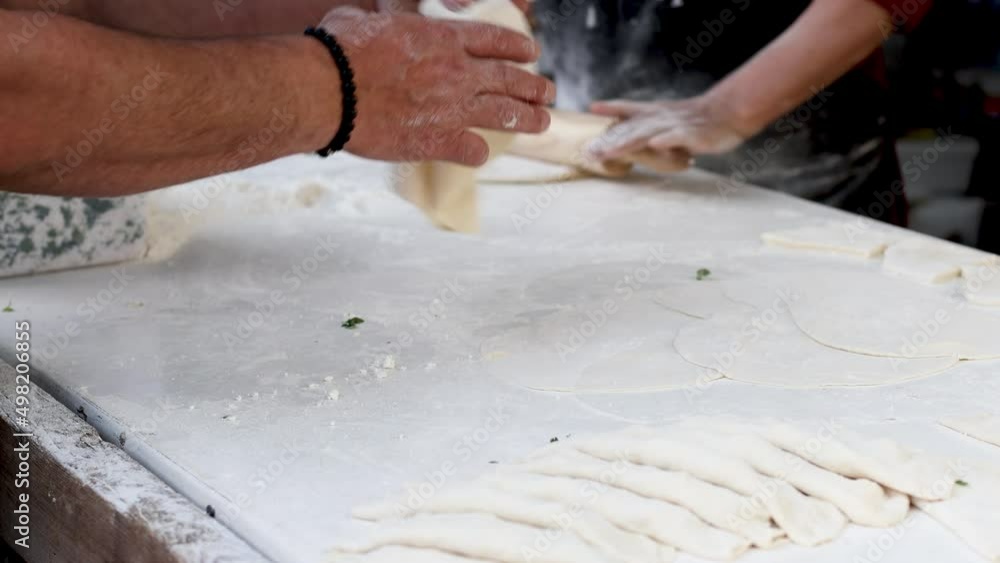 Women roll and cut dough, turkish cuisine, pastry dish, cooking traditional turkish food Women roll and cut dough, turkish cuisine, pastry dish, cooking traditional turkish food