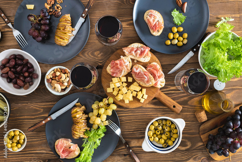 Dinner table with different food and wine, top view