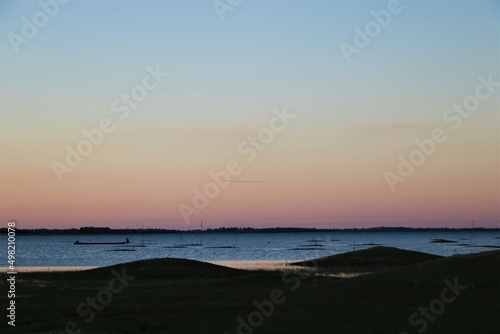 Scenery of evening time after sunset on blue lake and gold sky
