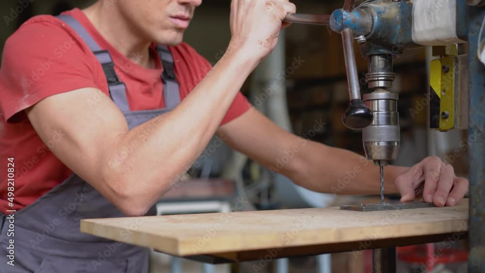 Faceless carpenter drilling steel in professional workshop Faceless carpenter drilling steel in professional workshop