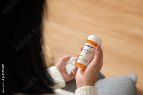 asian woman reading pill prescription when get flu on soaf at home