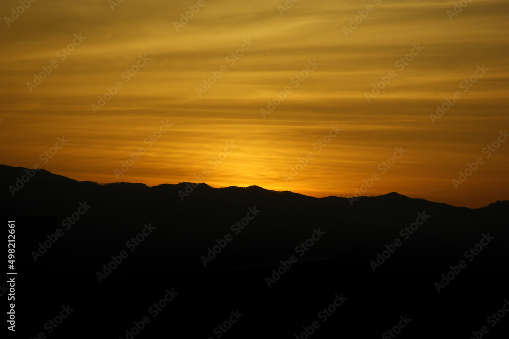 the golden sunset and the silhouette of the mountains