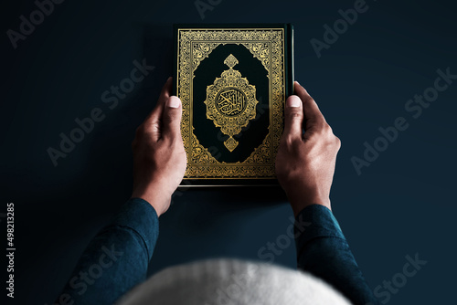 Muslim man holding holy quran photo