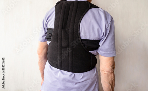 Orthopedic lumbar corset and back posture corrector. Posture corrector for the spine. Correction of scoliosis in an old woman.