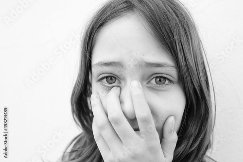 Little girl covering her face with her hands