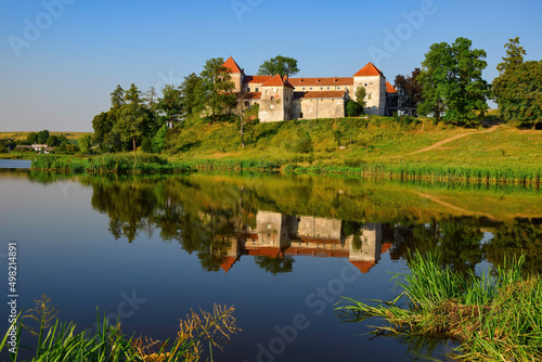 Picturesque summer scenery with medieval Svirzh Castle reflected in lake water. Lviv region, Ukraine